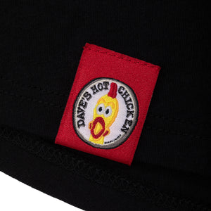 tee shirt has bright red patch with the dave's hot chicken logo stitched